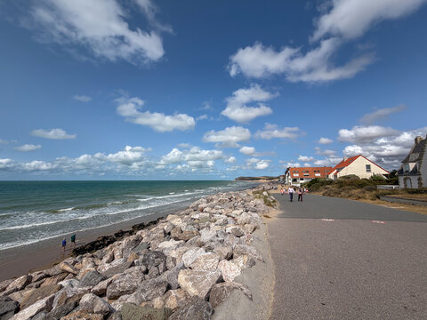 Wissant, France, July 21, 2026 - Coastal promenade with rock seawall and seaside houses along the beach in Wissant, France