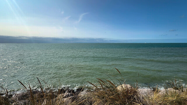 Panoramic sea view over the English Channel with coastal dune grass and distant cargo ships in Wissant, France
