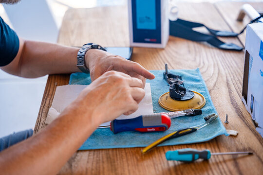 Close up of repairing yacht equipment with hand tools during a sailing trip on the Adriatic Sea. Concept of boat maintenance, DIY repair, seamanship, technical skills and self-sufficient sailing.
