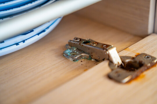 Corroded cabinet hinge inside a sailing yacht exposed to saltwater environment. Marine corrosion highlighting maintenance challenges and long term boat ownership.