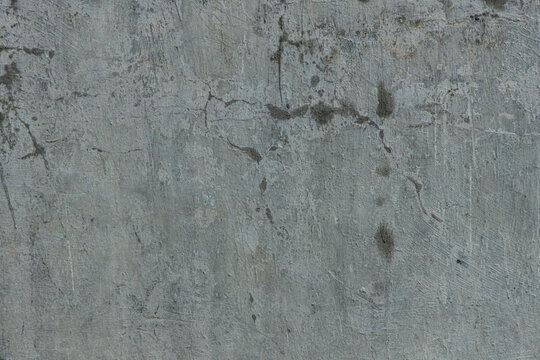 Concrete wall with cracks and stains showing signs of wear and aging