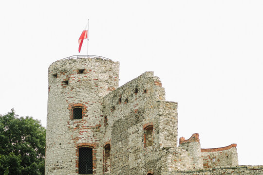 Old stone castle tower ruin with Polish flag