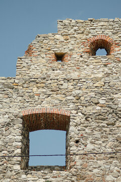 Weathered stone Polish castle wall with arched windows real photography