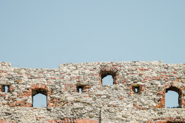 Long stone castle wall with arched openings and blue sky detailed closeup photography © Artem