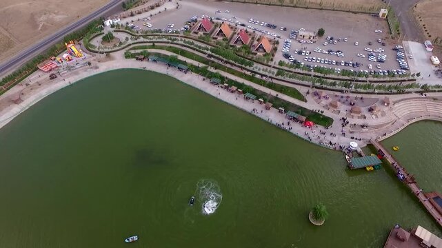 Stunning overhead aerial shot of entire flyboard recreational lake area with activity and surrounding park infrastructure.