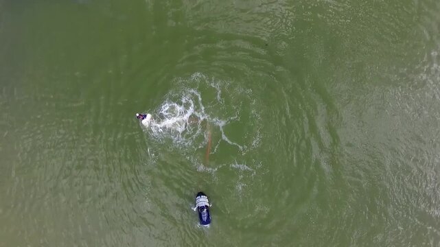 Close dynamic drone view captures intense water spray and motion of flyboard rider executing advanced maneuvers.