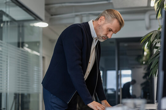 Confident stylish european man sitting at workplace, executive leader manager smiling.