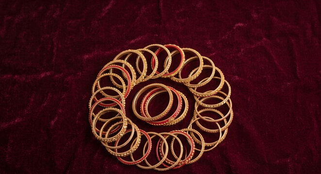 Traditional red and gold Indian bangles arranged on rich velvet background for bridal jewelry, wedding fashion and festive cultural themes