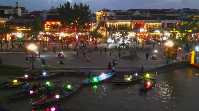 Aerial view of embankment with cafes and river with boats and bridge in Hoi An.