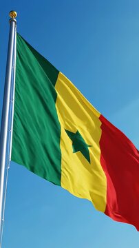 National Flag of Senegal Waving in Clear Blue Sky - The national flag of Senegal is shown waving proudly on a flagpole against a vibrant, clear blue sky.
