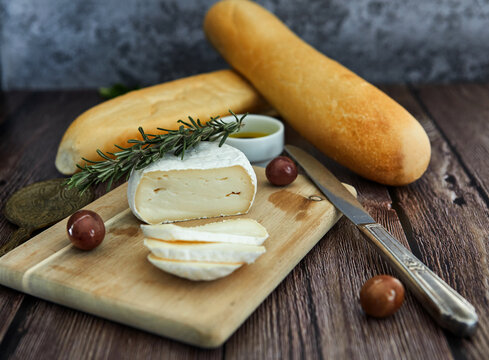 Cheese on a wooden table with olives and bread. Soft focus concept