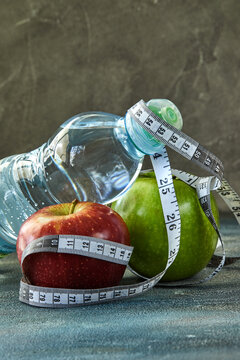 Attributes of a healthy lifestyle. Fruit, a bottle of water, a meter on a blue with a divorce background. Calorie counting. Diet plan. Side view. Close-up. Sport and healthy mode.