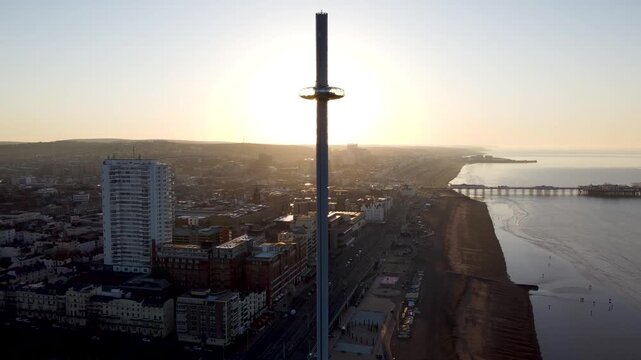 Sunrise behind tall observation tower i360 over the cityscape of Brighton