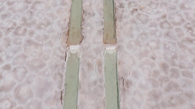 Abstract aerial overview of patterned salt crust at Salinas Grandes, drone flyover of symmetrical parallel trenches
