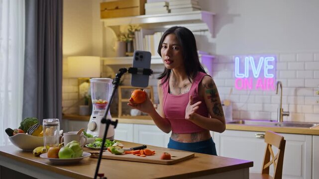 sport asian girl gen z  talk selfie video mobile phone camera to anti aging expert modern health care.vlogger or asian woman coach live in kitchen room.Online diet food weight loss HDL meal plan.