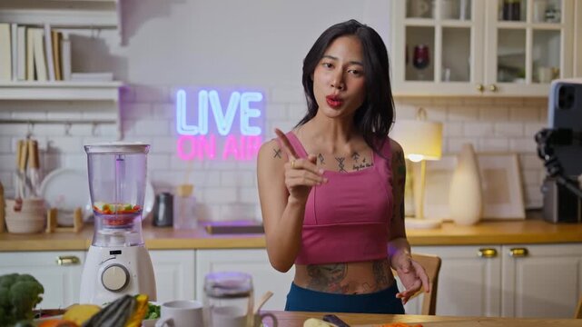 sport asian girl gen z  talk selfie video mobile phone camera to anti aging expert modern health care.vlogger or asian woman coach live in kitchen room.Online diet food weight loss HDL meal plan.