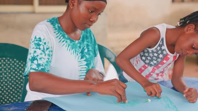 Mother teaches sewing. Child learning outdoor sewing skills. Community setting with focused lesson on hand stitching. Warm daylight illuminates mother instructing child in sewing on green chair