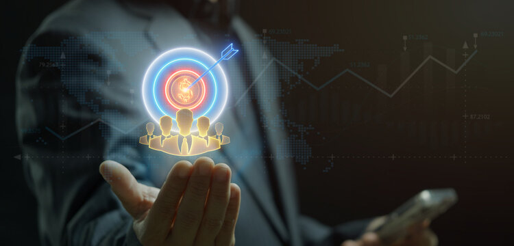 Businessman open hand supporting glowing target bullseye with arrow over group of user profile avatars. Target market audience analytics, customer segment focus, and goal achievement drive concept.