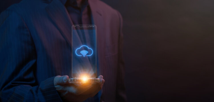 Businessman open hand supporting transparent glass screen displaying glowing cloud wi-fi signal icon over display. Wireless cloud network connectivity and mobile internet data access system concept.