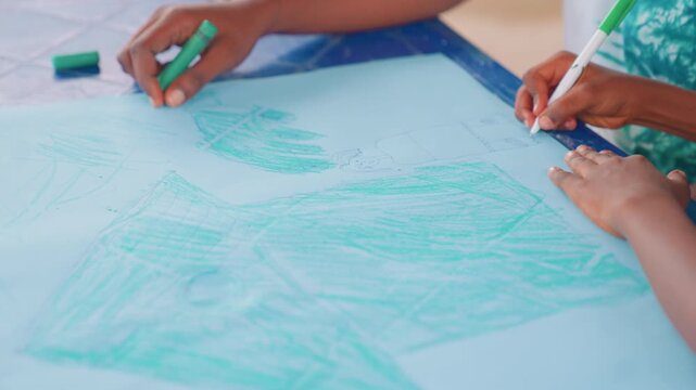 Black mother and child collaborating on large paper, two sets of dark hands filling blue sheet with sweeping green strokes, joyful classroom vibe, community creativity and mentorship