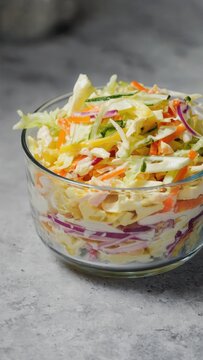 Layered coleslaw salad in clear glass bowl