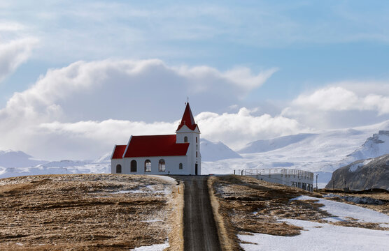 Ingjaldsholl church in Hellissandur, Iceland in the field of blooming lupine flowers with background of Snaefellsjokull mountain. Beautiful sunny scenery of summer in Iceland.