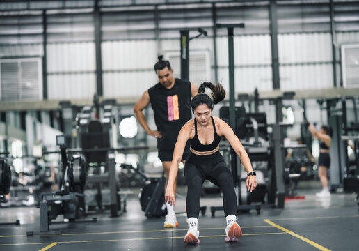 Woman training Burpee Jump at gym 