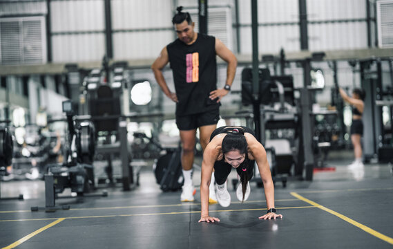 Woman training Burpee Jump at gym 