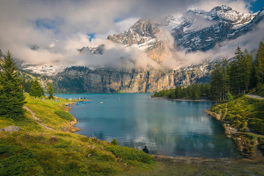 Oeschinensee lake and high foggy mountains in background, Kandersteg, Switzerland