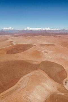 Aerial view of rolling desert hills and snow-capped mountains, Sud L&iacute;pez, Potos&iacute;, Bolivia