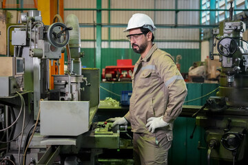 Industrial worker machinist factory machine metal manufacturing safety helmet glove, focused man operates milling equipment inside workshop with protective eyewear and workwear, production concept © ADD PHOTO
