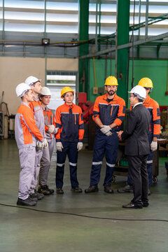 Engineer factory worker safety helmet group meeting industrial training team in workshop with manager briefing staff