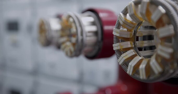 Electrical connector insulator bushing assembly inside industrial switchgear room with slow shallow focus lateral movement.
