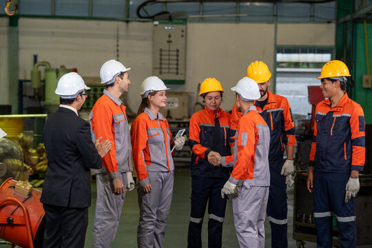 Engineer factory worker helmet uniform safety team industry group inside production plant with machinery and gear
