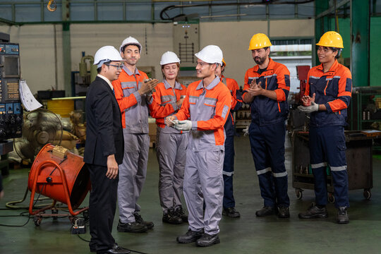Factory engineer worker hard hat safety uniform industry team, engineer team applauding with manager in manufacturing workshop