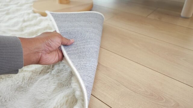 Removing a rug from a wooden floor in a living room
