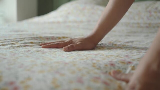 Making a bed in a bright room during the day