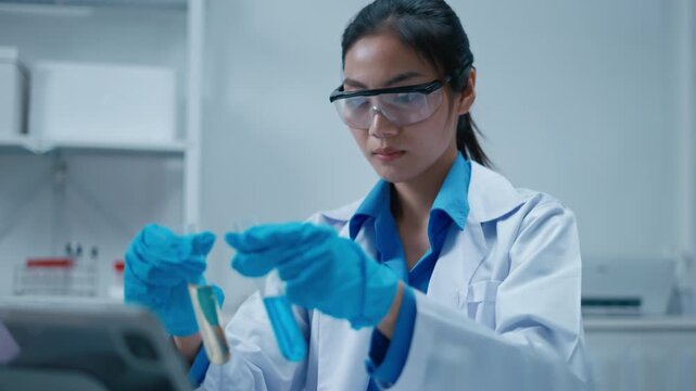 Asian Researcher using a microscope in the clinical lab.Female Researcher working in the clinical laboratory,Medical or scientific researcher or Asian woman doctor looking at professional microscope.
