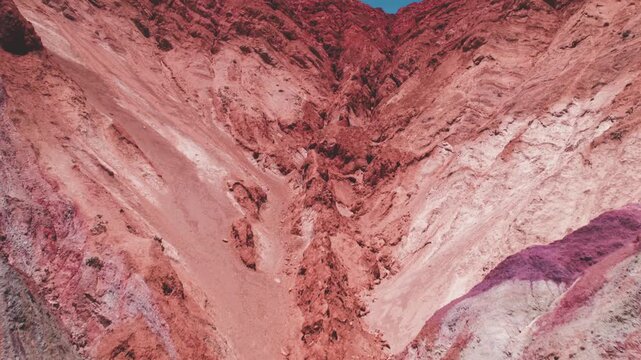 4K drone aerial view of Purmamarca, Jujuy, Argentina. Colorful Andean village surrounded by the iconic Hill of Seven Colors, with unique red, orange and green mountain formations.