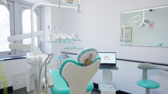 Modern dental treatment room with equipment, dental chair, and computer display