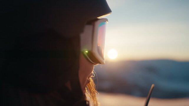 Attractive young adult woman watching sunset above mountains after climbing. Tourism and traveling sportswoman resting in modern ski resort, exploring and discovering planet, calmness and solitude