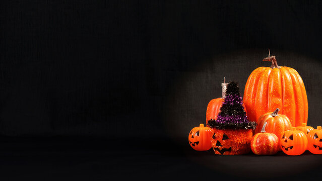 Halloween pumpkins with witch hat on dark background with copy space
