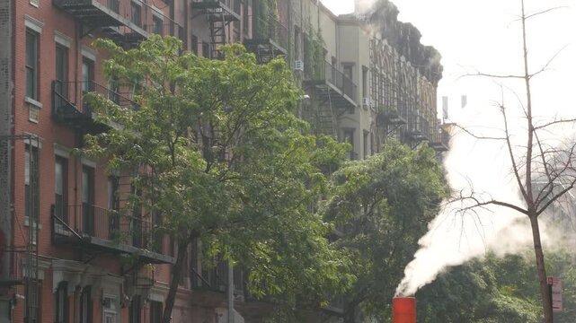 New York City urban residential buildings architecture, Manhattan classic street, United States of America. Typical red brick house, real estate property, USA. Fire escape metallic ladder. Hot steam.