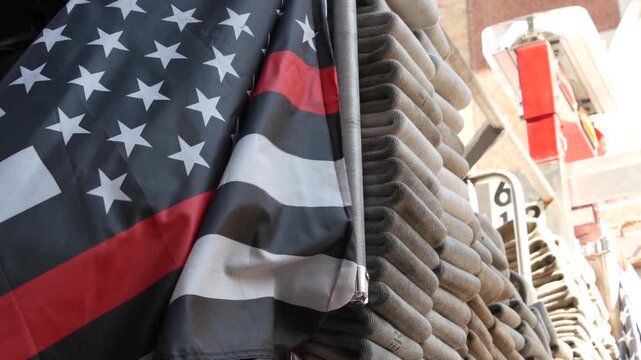 Red thin line black american flag on firefighter truck. Hose of firetruck and fire fighters symbol in New York, United States. 911 remembrance, fire department engine vehicle. September 11 Patriot Day