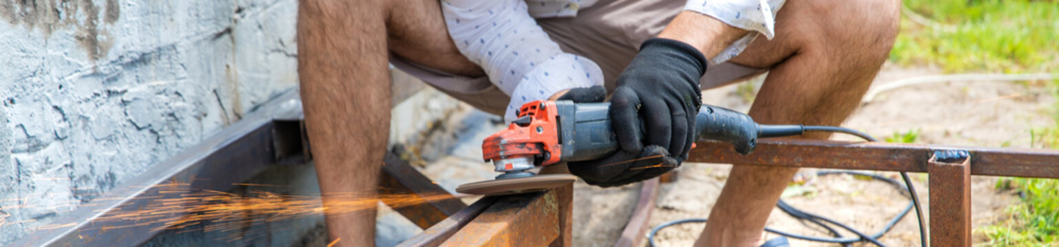 A man cutting metal with a grinder. Selective focus.