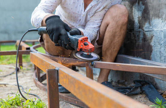 A man cutting metal with a grinder. Selective focus.