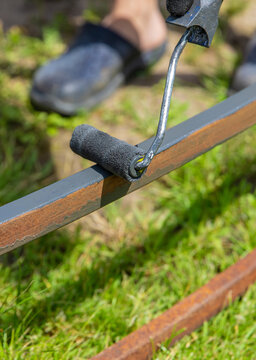 Man painting metal. Selective focus.