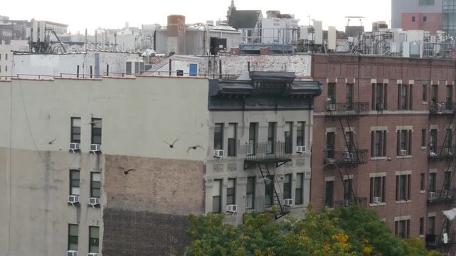 New York City urban residential buildings architecture, 125 street in Harlem, Manhattan, United States of America. Typical house in NYC, real estate property in USA. Fire escape metallic ladder.