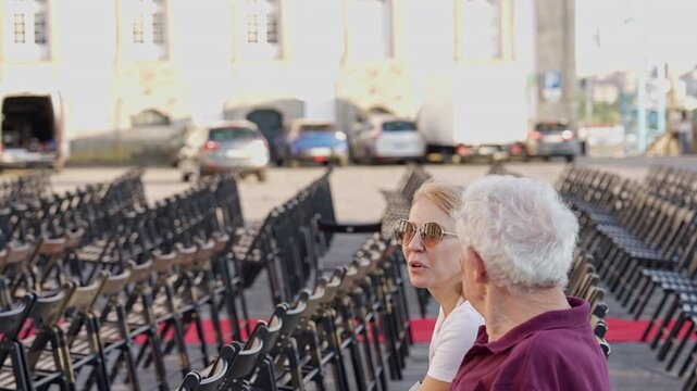 Portugal. Senior father and adult daughter talking at an outdoor event in Porto