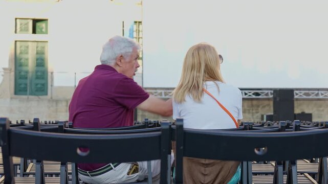Portugal. Senior father and daughter talking at an outdoor cinema event